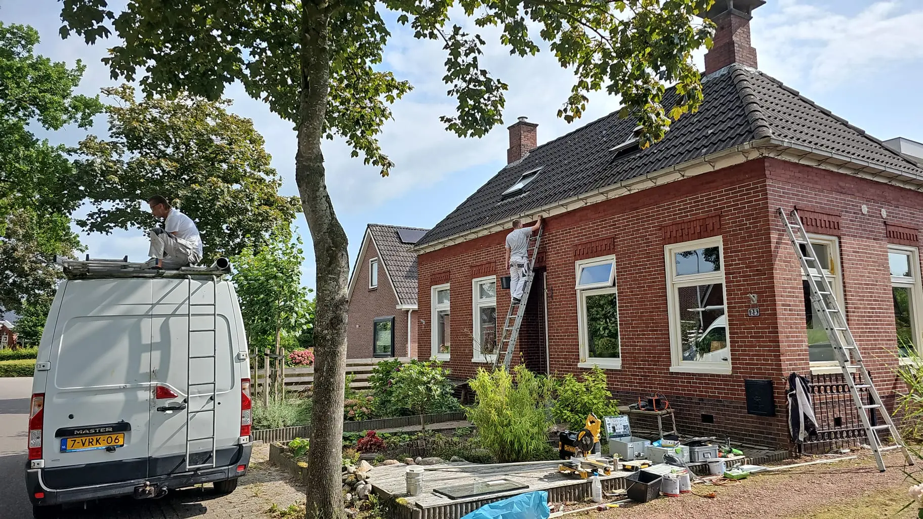 Roossien Totaalonderhoud schilder aan het werk op een steiger bij een woning