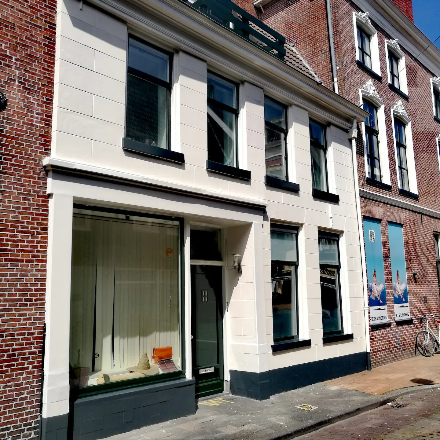 Een raam met een volledig rot kozijn waarvan een deel is weggeslepen om hersteld te worden